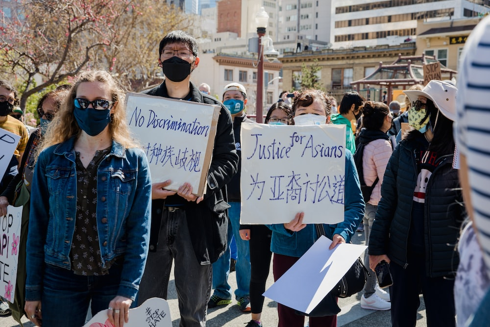 Asian American protesters holding placards at an AAPI violence protest in California