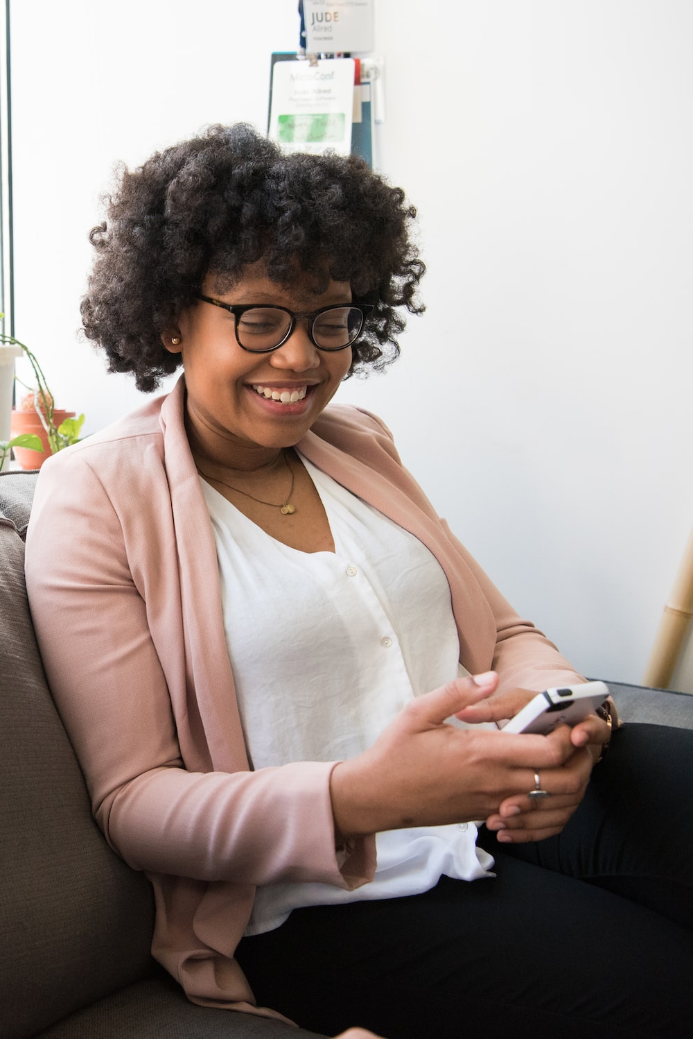 a South Asian woman smiling at her phone